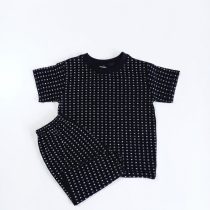 A black t-shirt and shorts co-ord set featuring a subtle, repeating white self-print pattern
