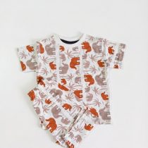 A white t-shirt and shorts co-ord set featuring a repeating pattern of orange and grey elephants and palm trees.