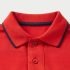 Close-up macro photograph of a red polo shirt collar and placket, highlighting the high-quality pique knit fabric texture, stitching details, and button craftsmanship.