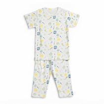 A professional studio flat-lay photograph of a kids' white short-sleeve t-shirt and matching pajama pants featuring a colorful celestial sun, moon, and planet print on a pure white background.