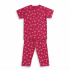 A professional studio flat-lay photograph of a magenta-colored kids' short-sleeve t-shirt and matching pajama pants featuring a white bow and heart pattern, displayed on a clean white background.