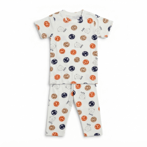 A professional studio flat-lay photograph of a kids' white short-sleeve t-shirt and matching pajama pants featuring a colorful "Party" themed circular print on a pure white background.