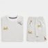 A professional folded product photograph of a folded kids' matching co-ord set, including a t-shirt and shorts with a geometric and safari animal print, laid flat against a clean, neutral off-white background.