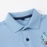 Detailed close-up of light blue polo shirt collar, placket, and pique fabric texture, label-free